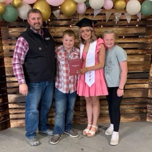 A family posing for a picture in front of balloons.