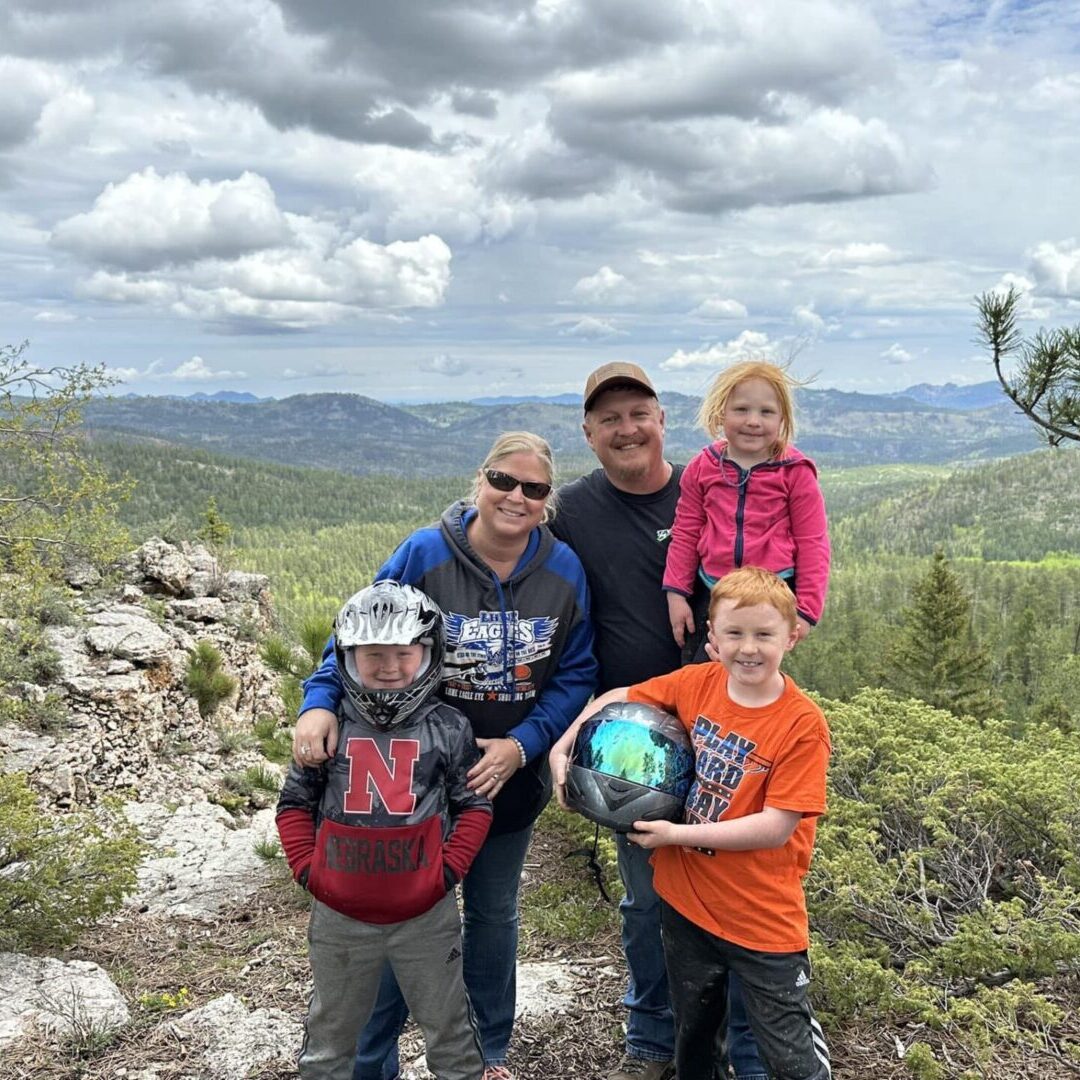 A family posing for the camera on top of a mountain.